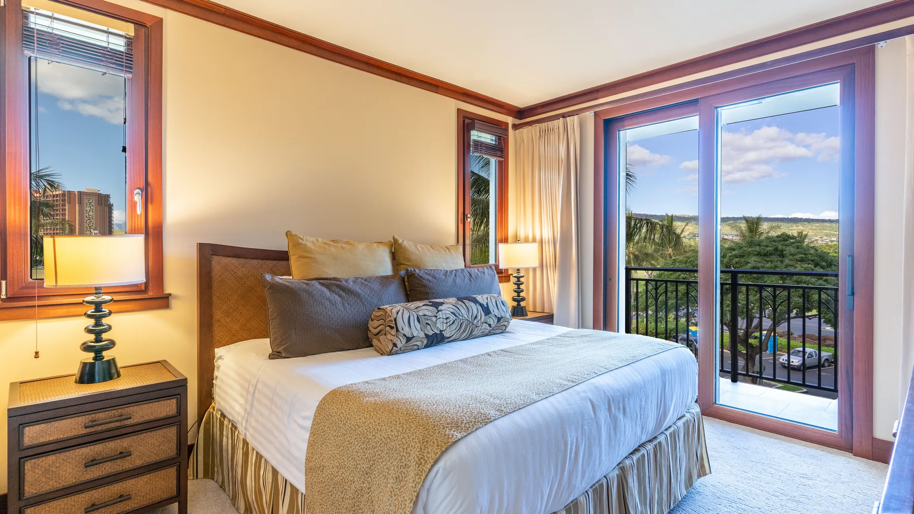 Un dormitorio con una cama bien tendida junto a grandes puertas de vidrio.