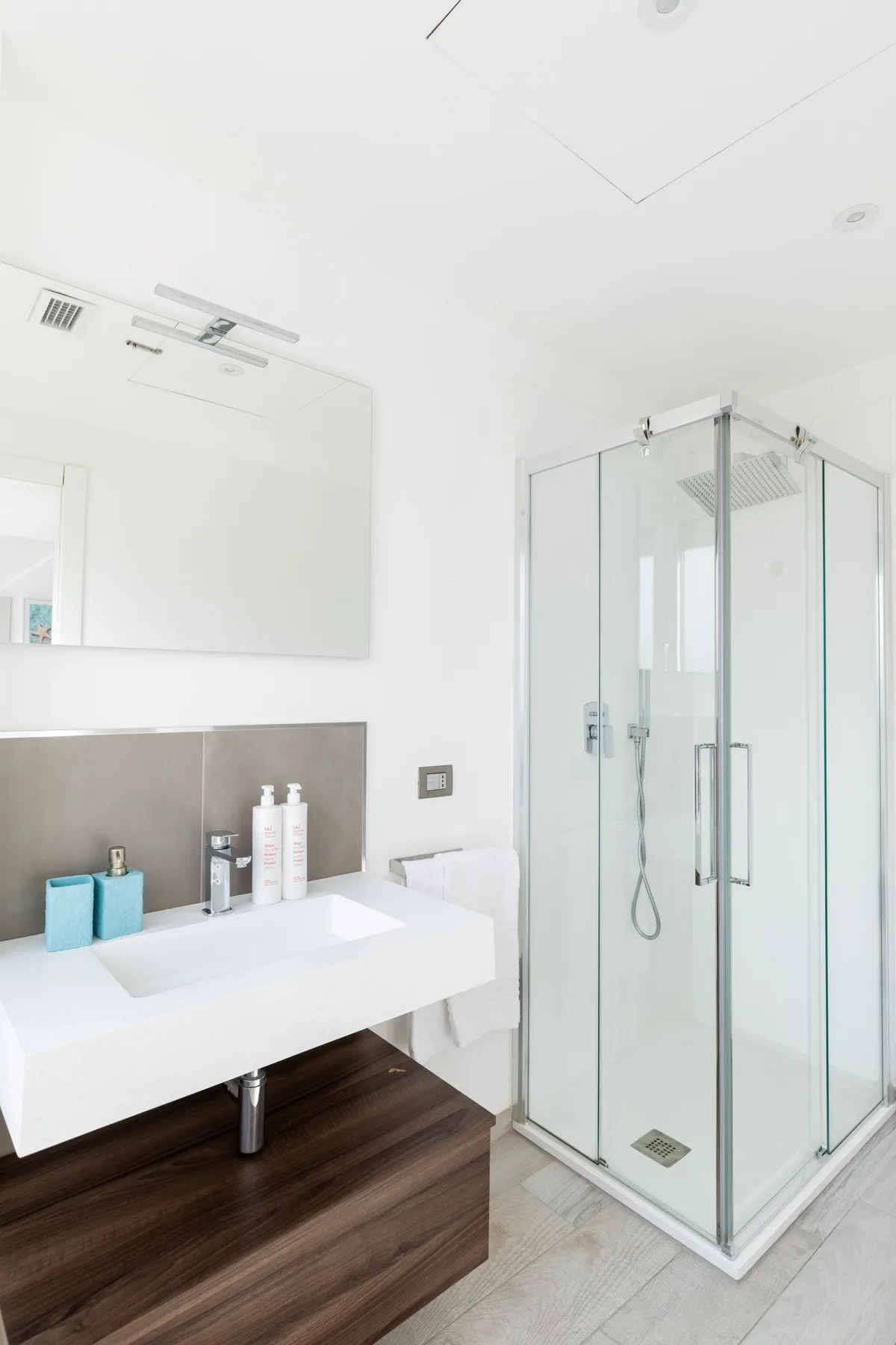 Un baño luminoso con lavabo y ducha de cristal.