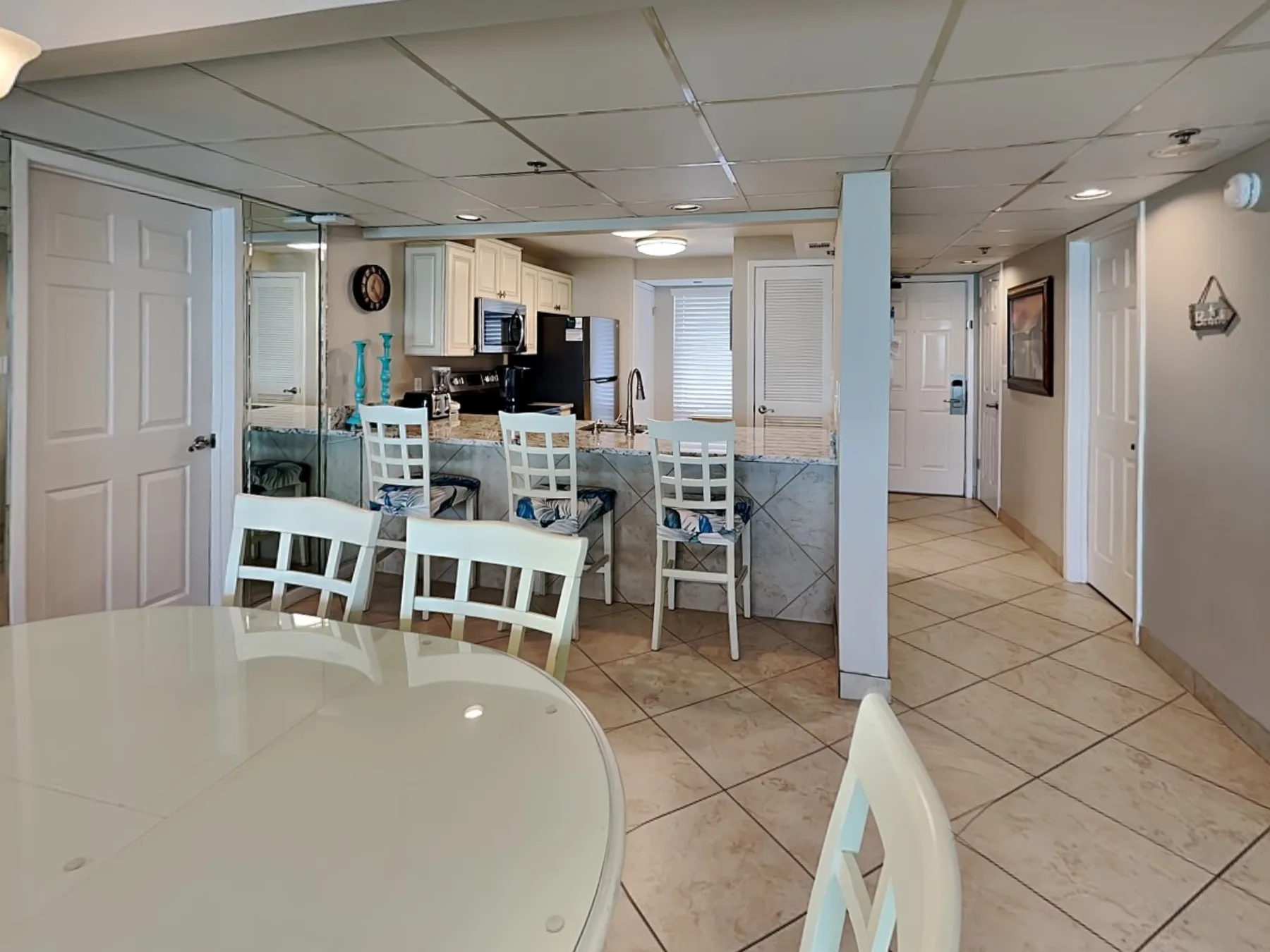 An open-plan kitchen and dining area with a tiled floor and table seating.