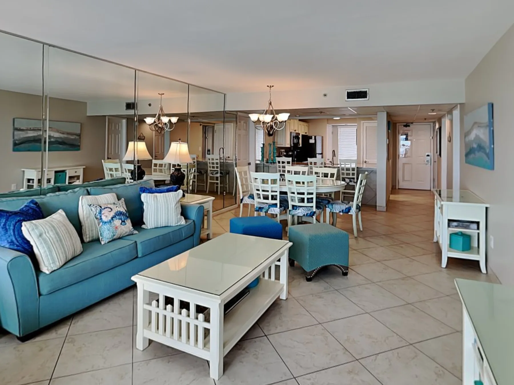 An open-plan living and dining area with blue seating and a white dining table.