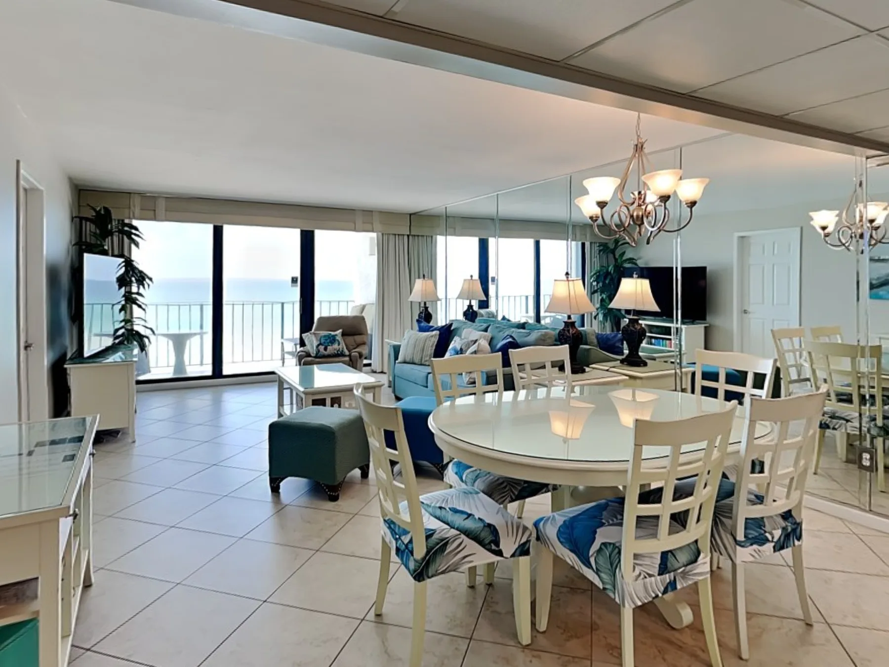 A bright living and dining area with seating beside large windows.