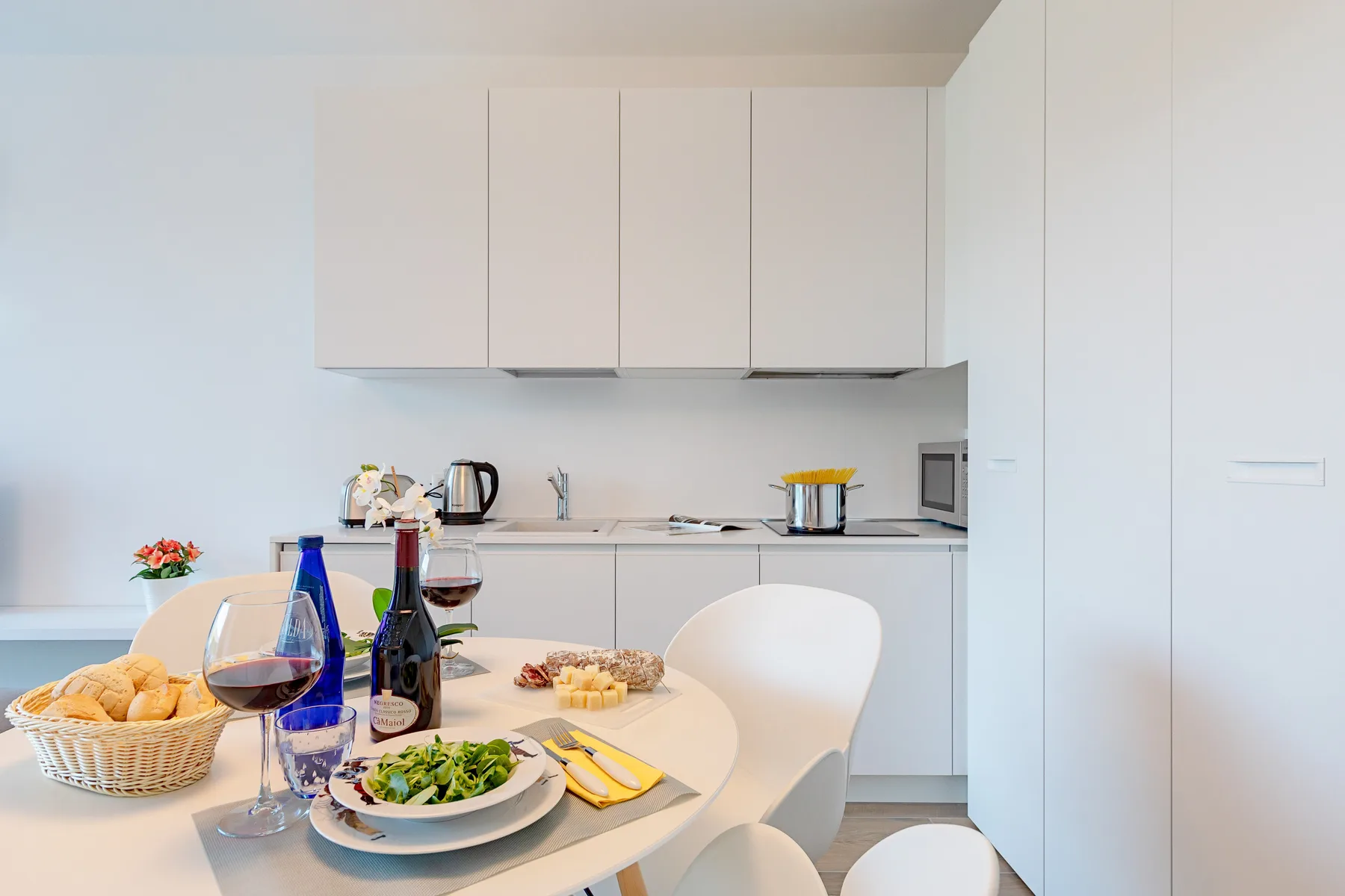Una cocina luminosa con comedor y una mesa preparada para comer.