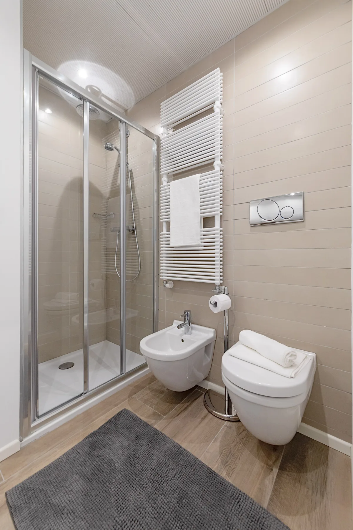 Un baño moderno con ducha de vidrio y lavabo suspendido.