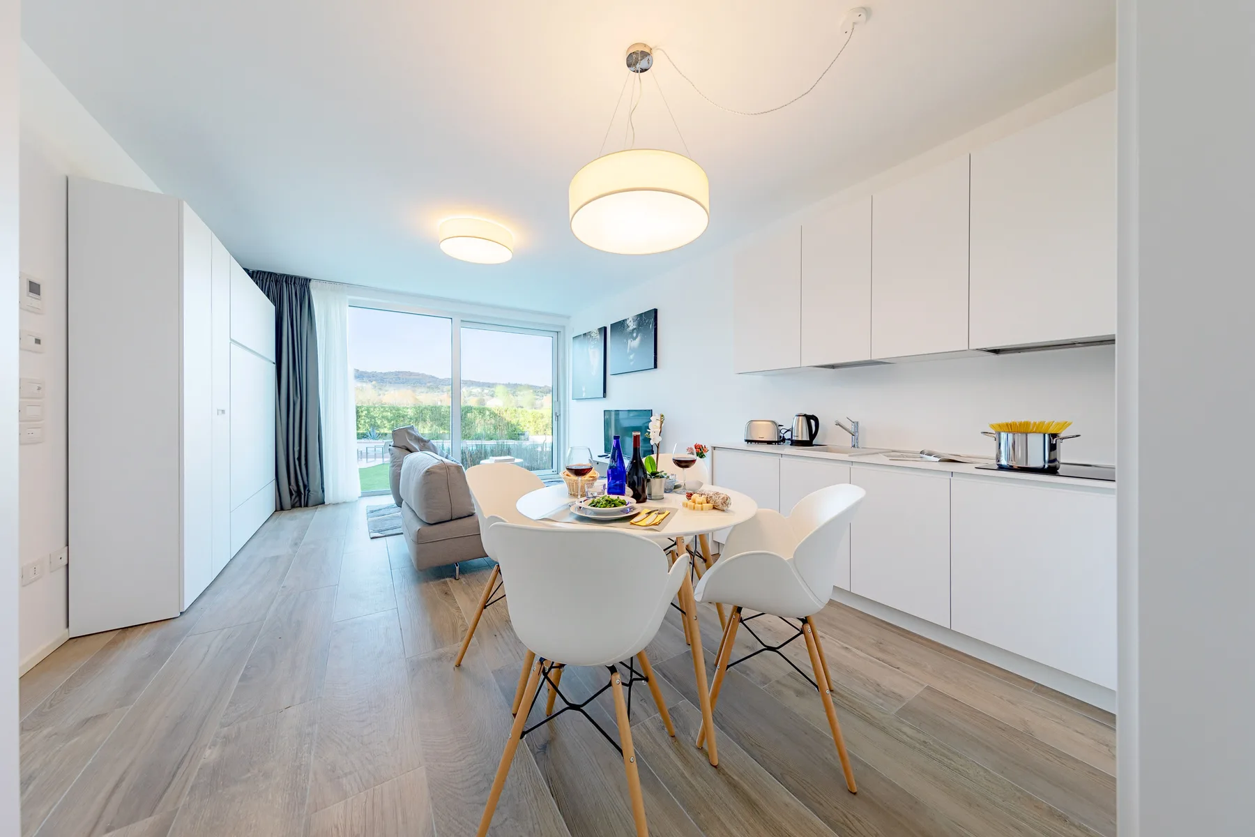 Una cocina luminosa con comedor y una mesa puesta junto a grandes ventanas.