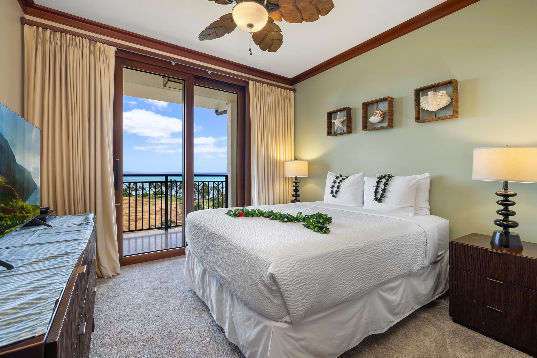 A bedroom with a neatly made bed and sliding glass doors opening onto a balcony.