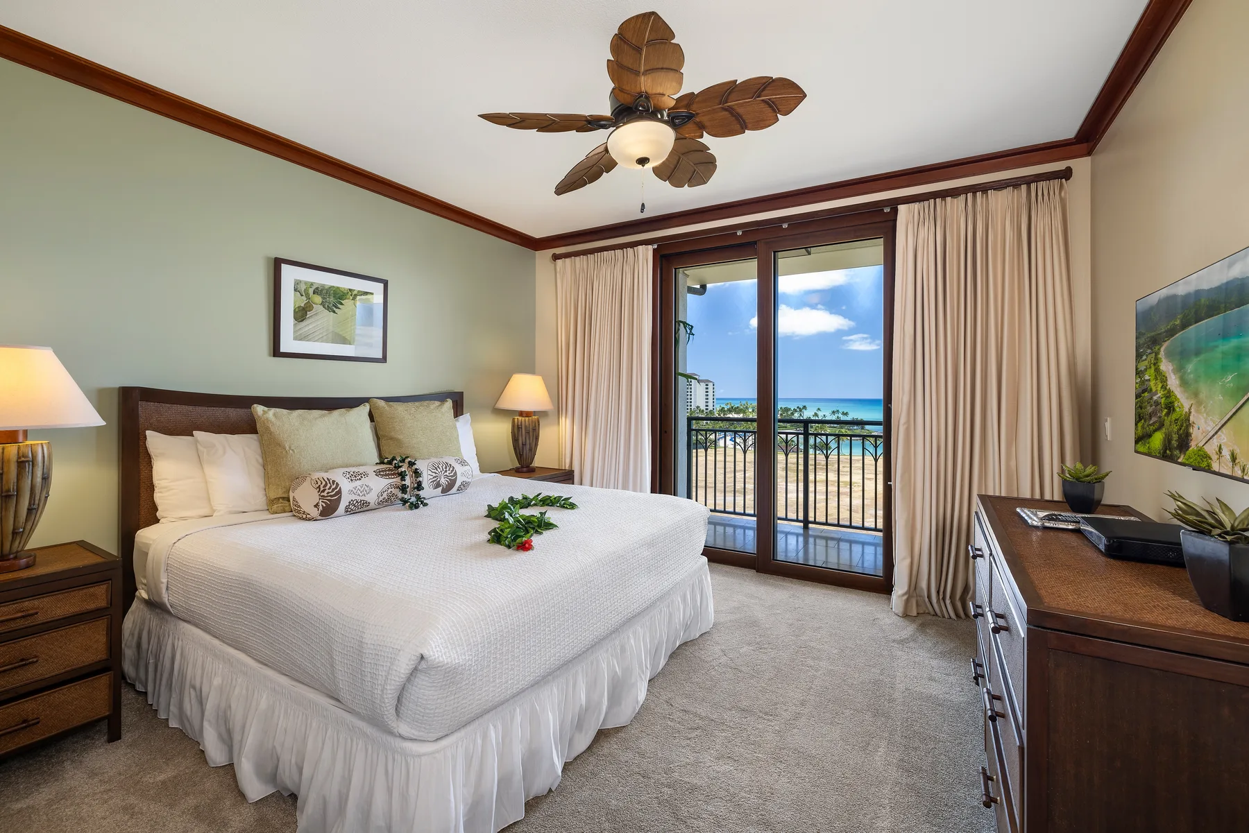 A bedroom with a neatly made bed and glass doors opening onto a balcony.