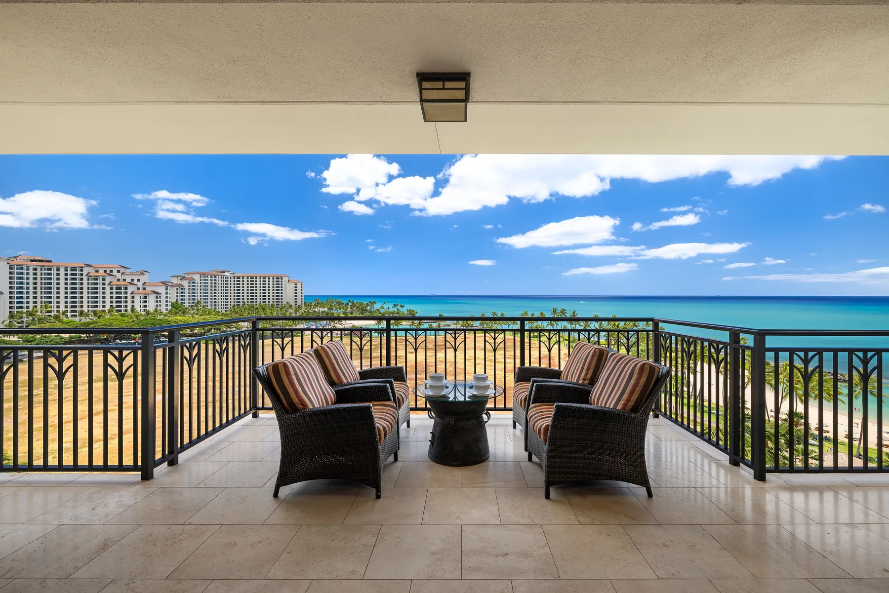 A covered balcony seating area overlooks the beach and ocean.