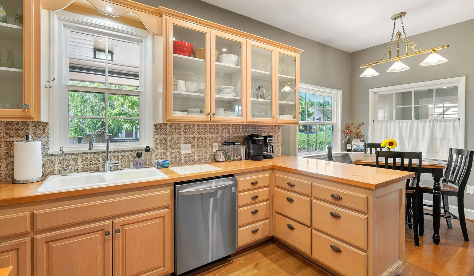 Una cocina luminosa con gabinetes de madera, una isla central y una mesa de comedor.