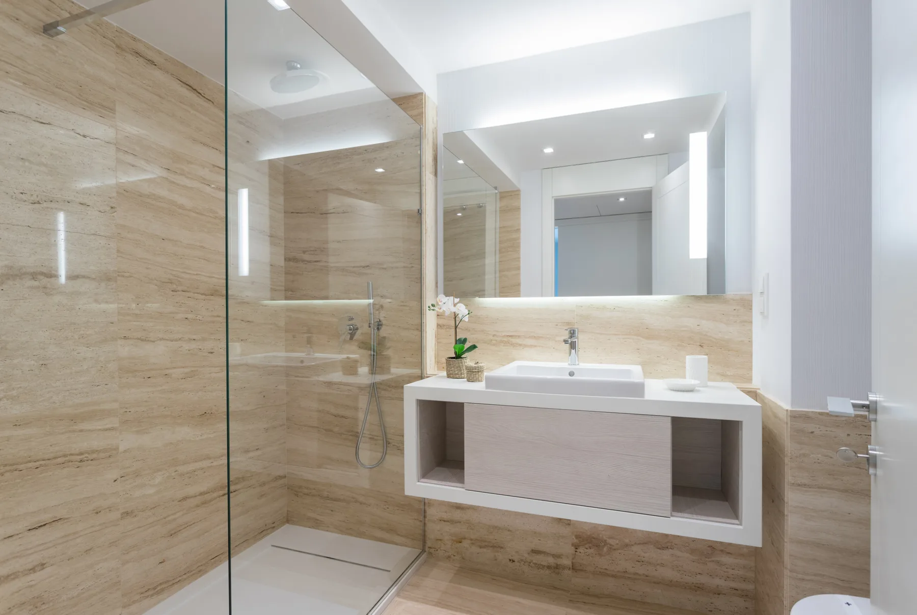 A bright bathroom with a glass shower and a floating vanity.