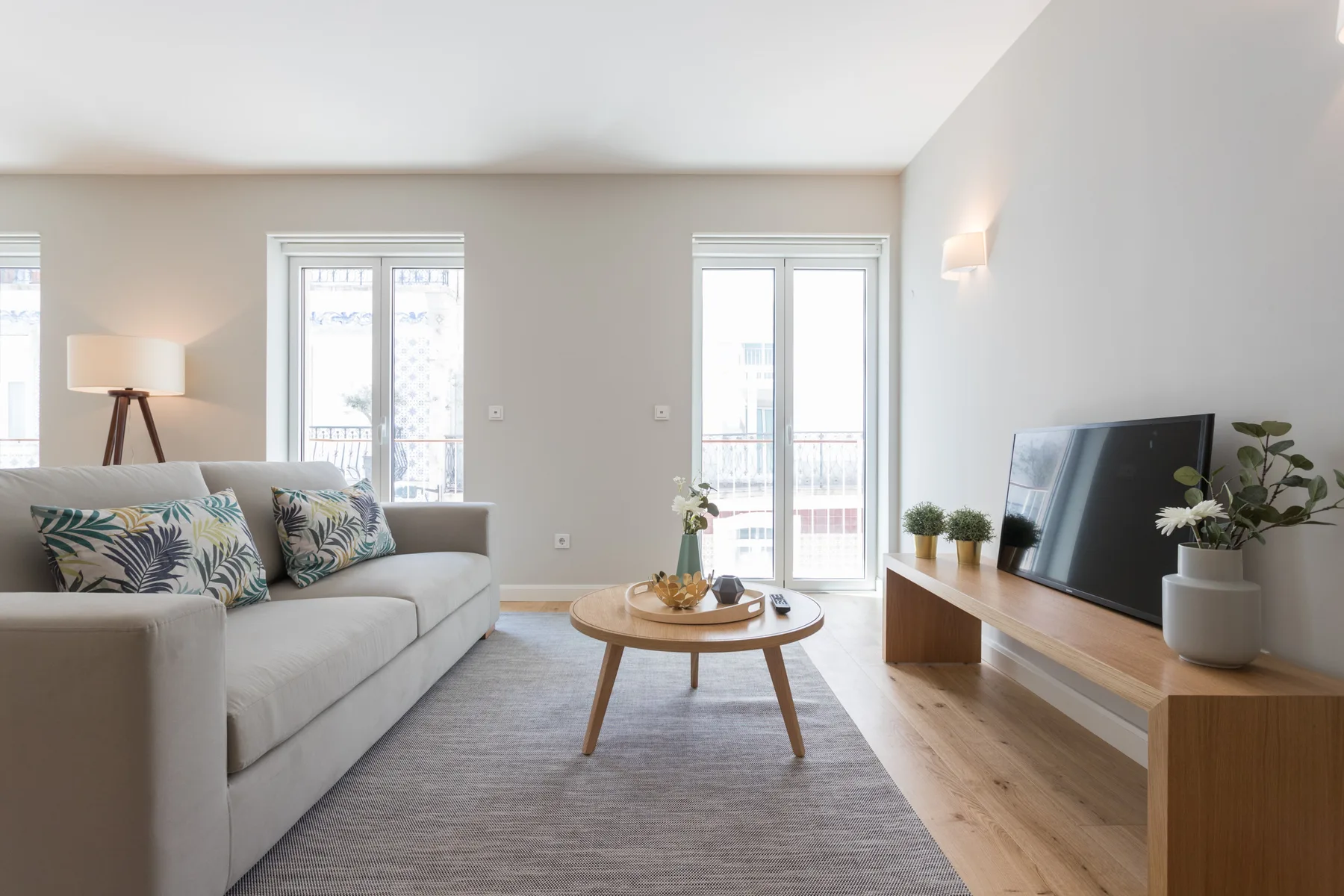 A bright living room with a sofa, coffee table, and television.