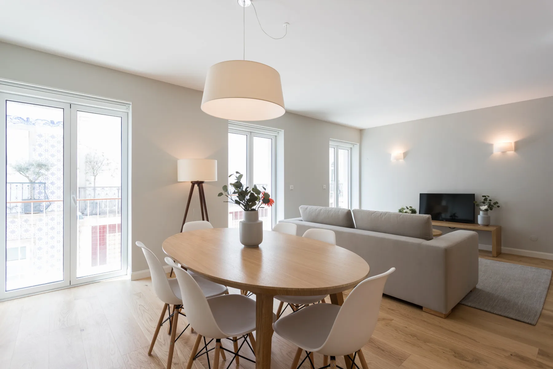 Living and dining area with a dining table, seating, and large windows.