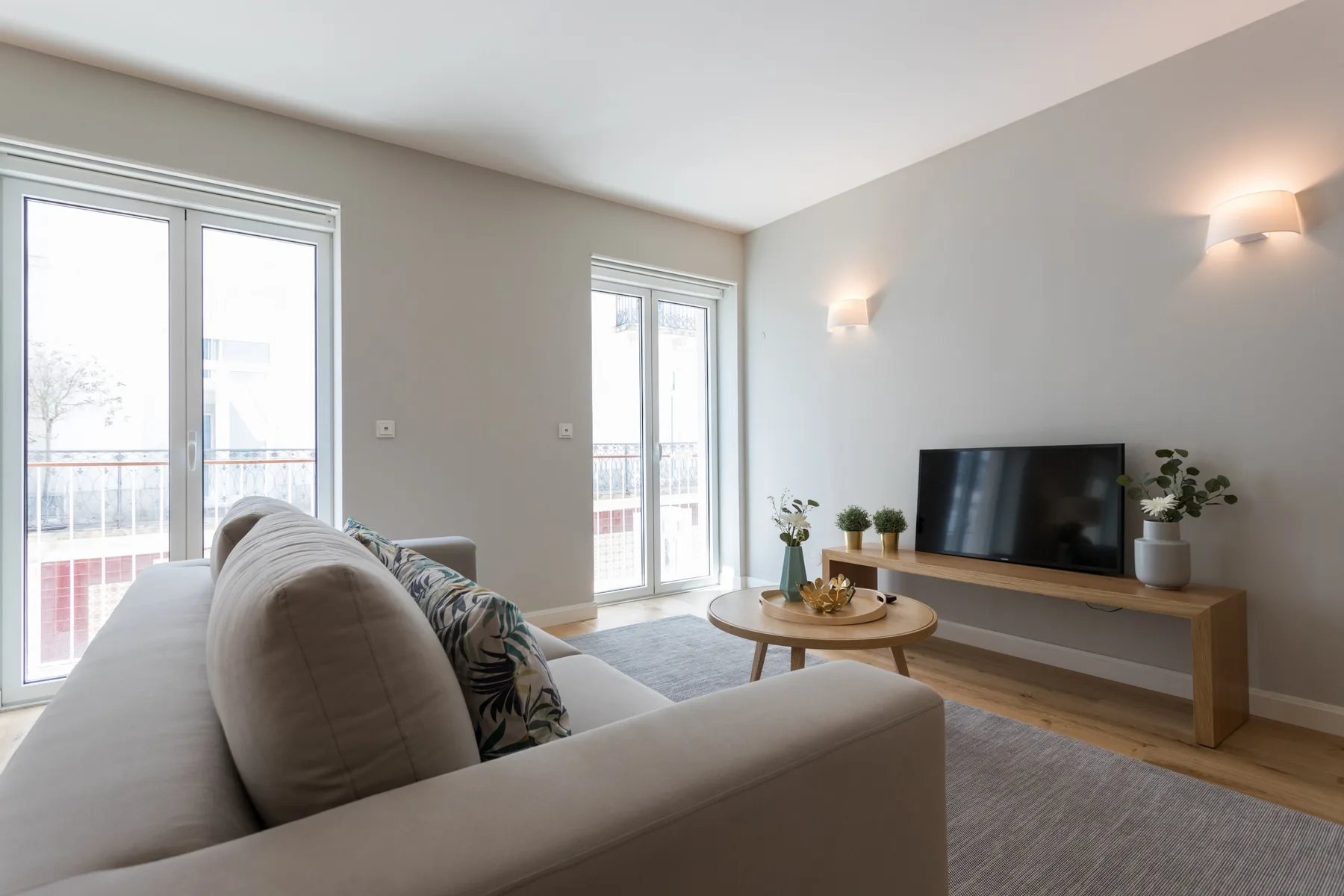 A bright living room with seating, a coffee table, and a television.