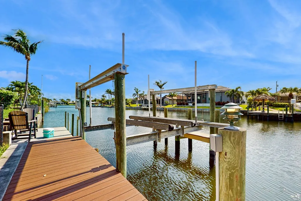 A waterfront dock extends over calm water beside a wooden deck.