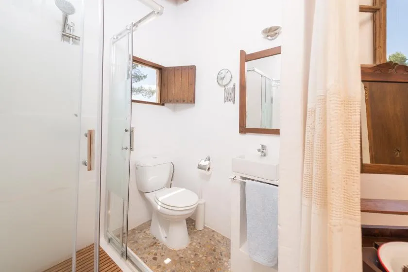 A bright bathroom with a shower, toilet, and sink.