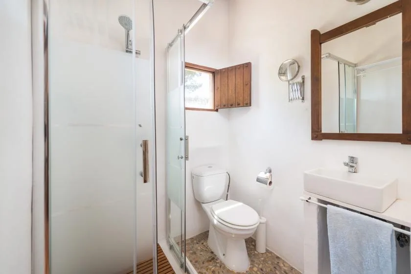 A bright bathroom with a shower, toilet, and sink.