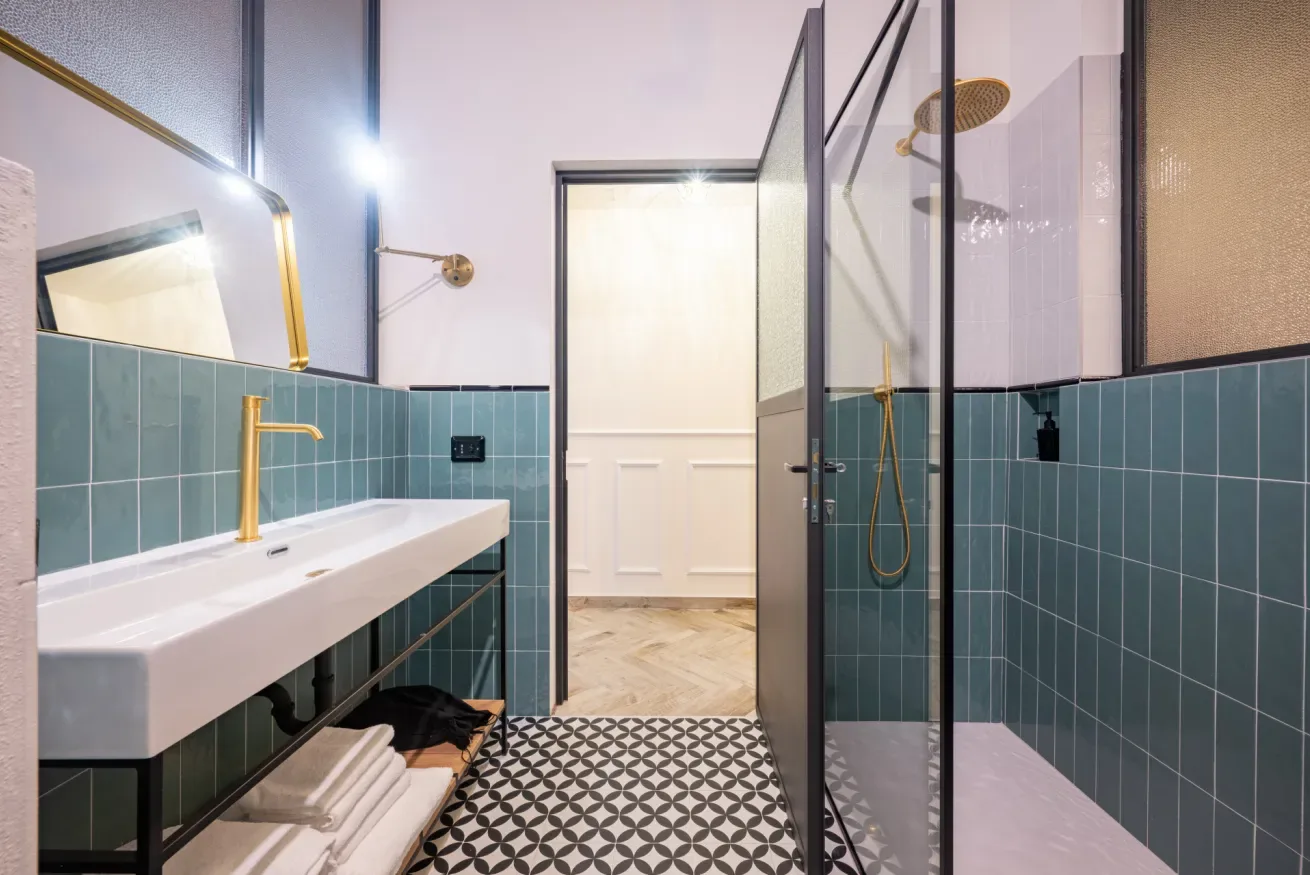 Un baño moderno con una encimera larga y una ducha de vidrio.