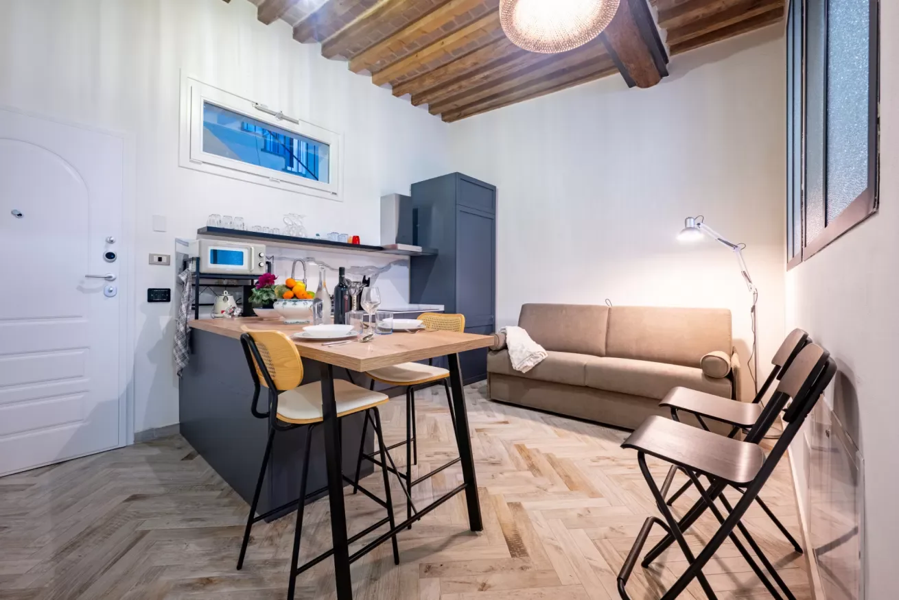 Una cocina y comedor compactos con mesa, sillas y sofá.