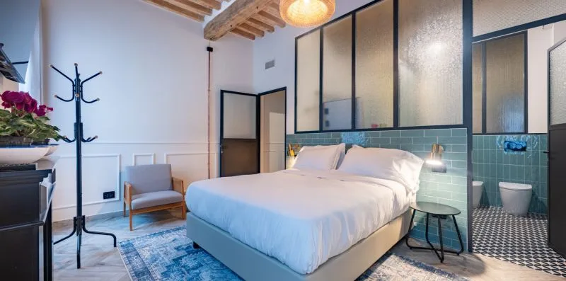 Un dormitorio con una cama junto a una zona de baño alicatada.