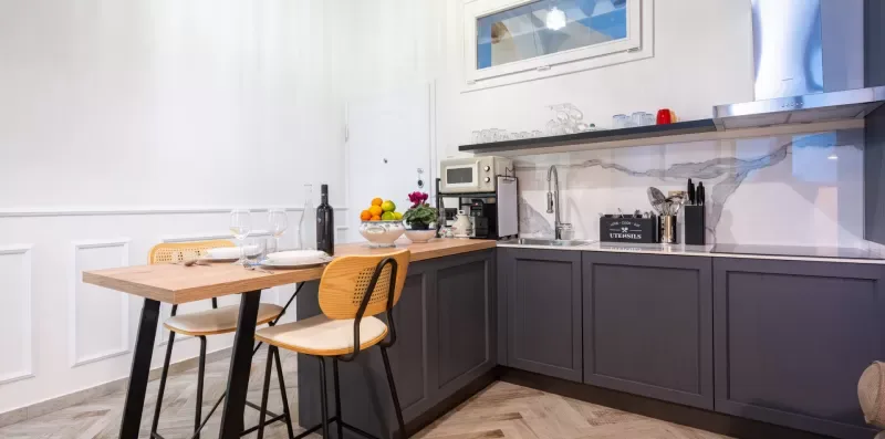 Una cocina con gabinetes oscuros y una pequeña mesa de comedor.