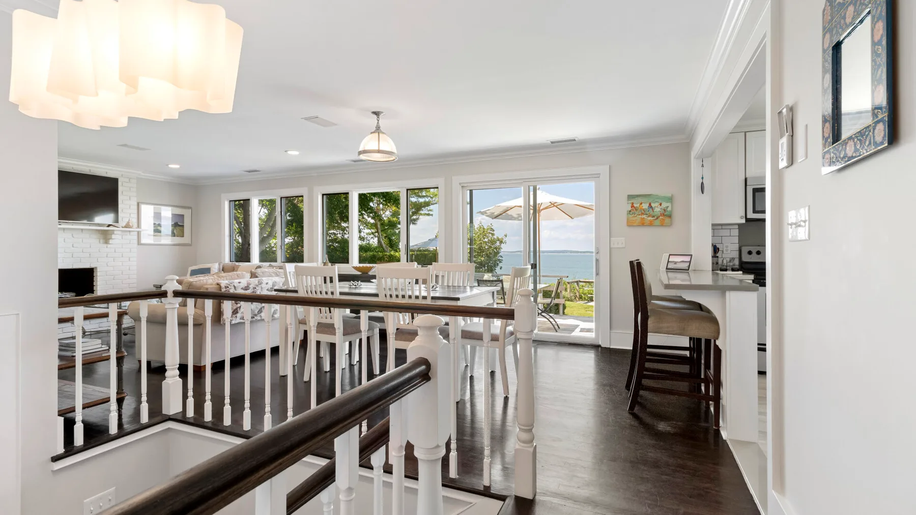 Un comedor luminoso con una mesa larga junto a grandes ventanas y puertas de vidrio.