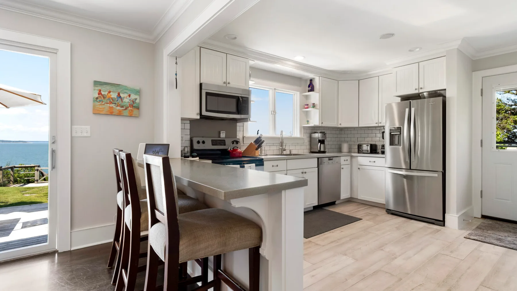 Una cocina luminosa con gabinetes blancos y una isla central.