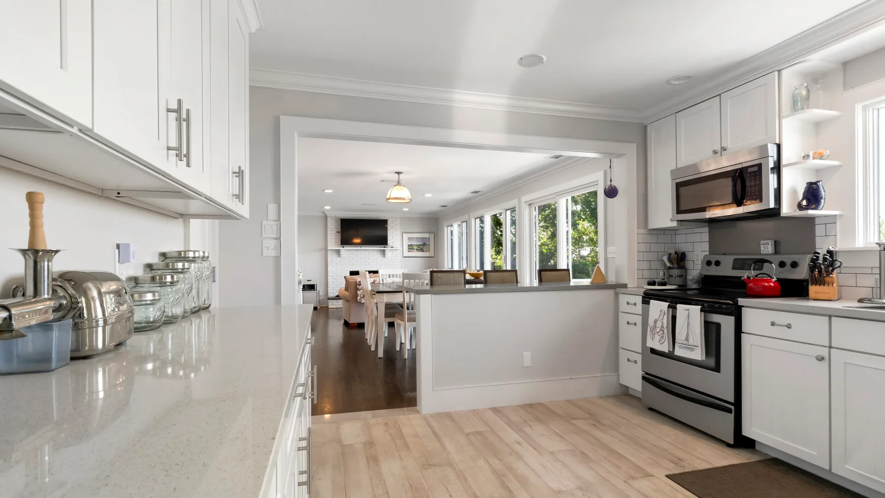 A bright kitchen with white cabinetry, a countertop, and a cooking range.