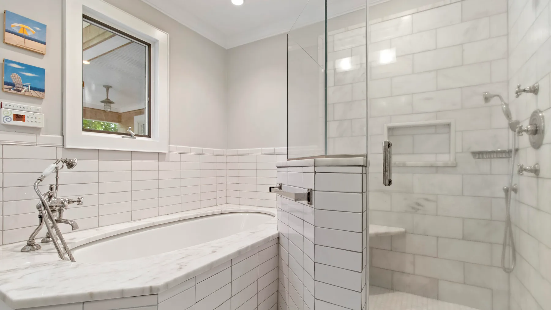 Un baño alicatado con bañera junto a una ducha con mampara de vidrio.