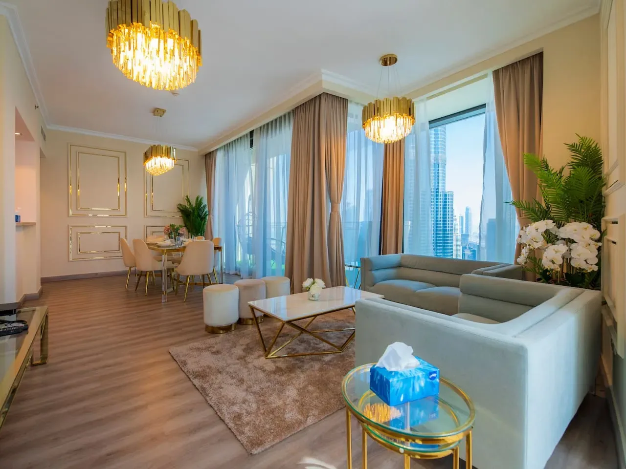 A bright living room with seating, a coffee table, and large windows.