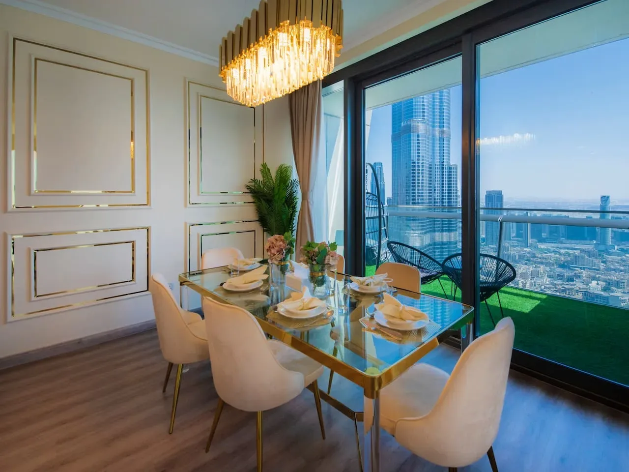 A dining area with a glass table and large windows overlooking the city.