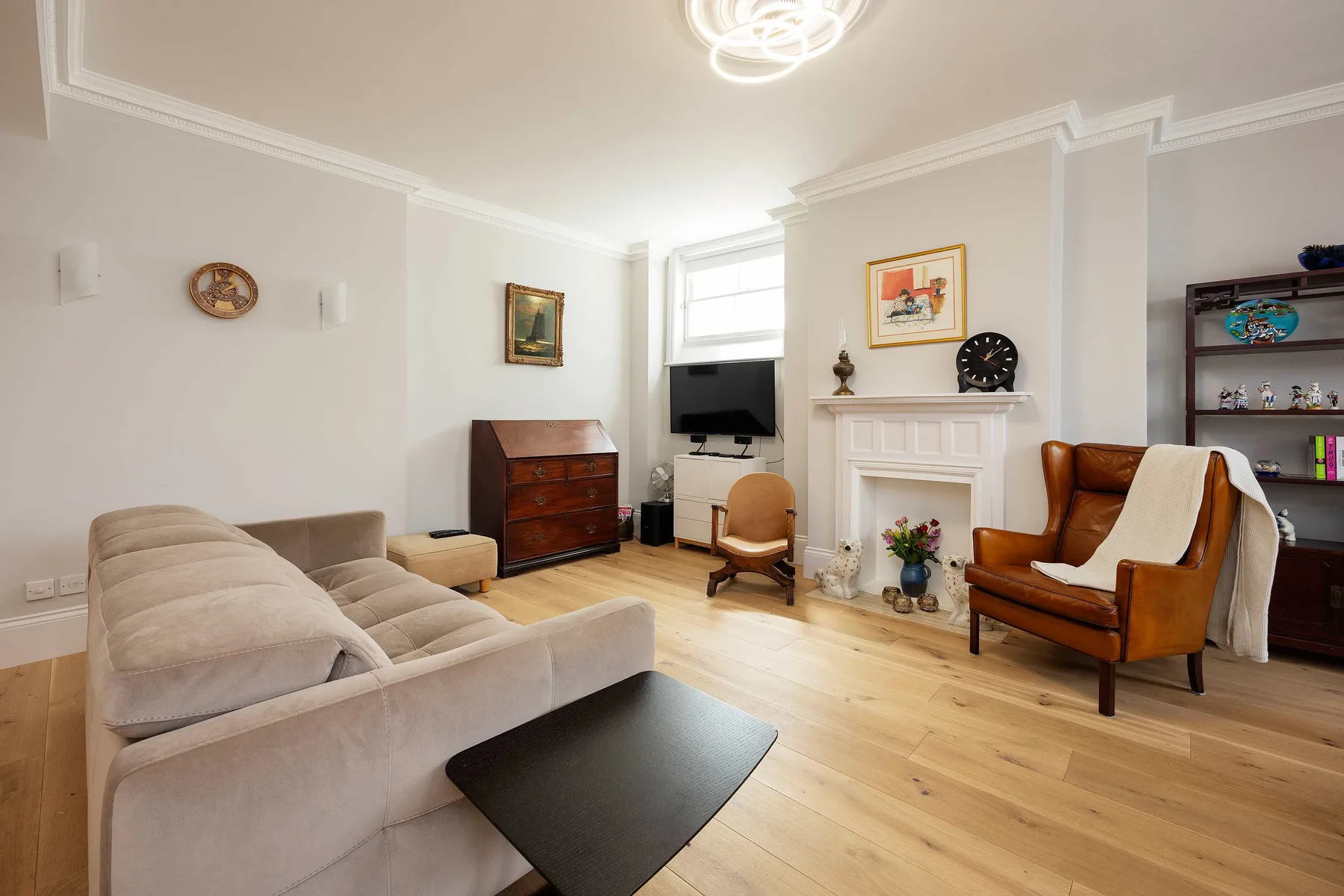 Una sala luminosa con chimenea, asientos y un televisor.