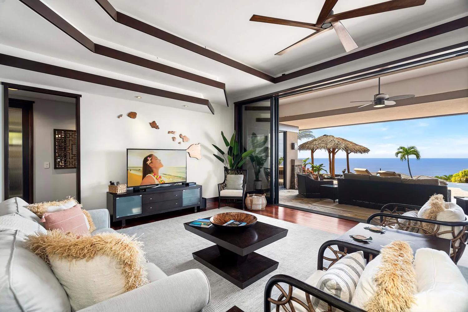 Una sala luminosa se abre a un patio con asientos y vistas al mar.