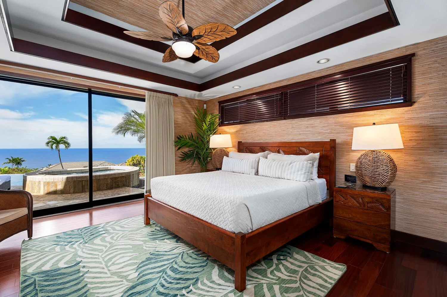 Un dormitorio con una cama de madera y puertas corredizas de vidrio con vista al mar.