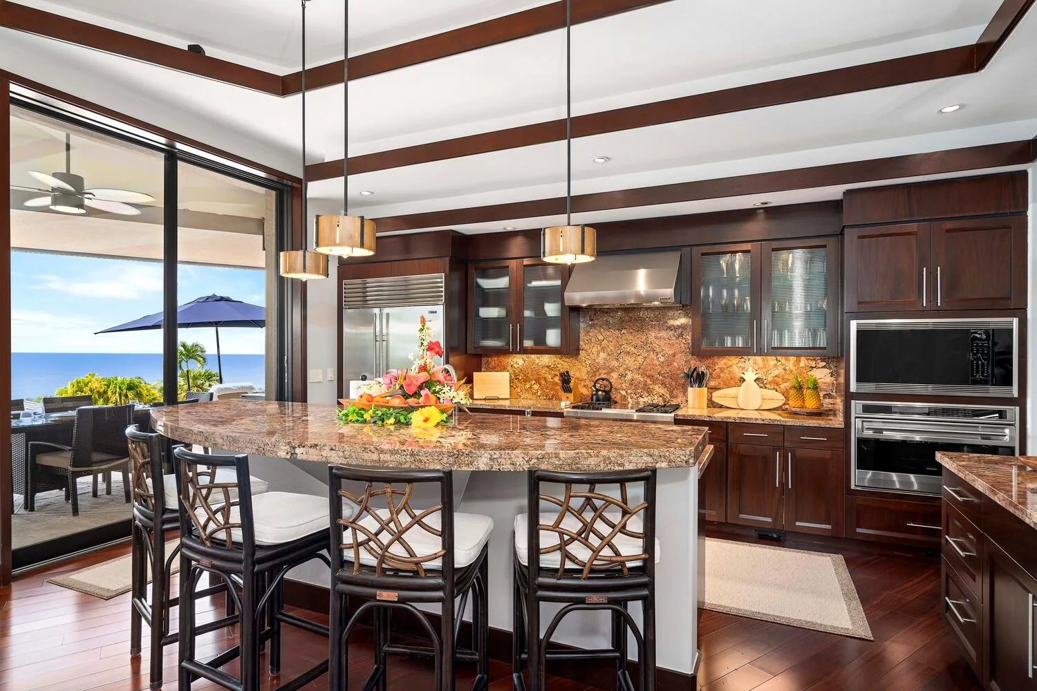 Una cocina amplia con una isla central y grandes ventanas con vista al agua.