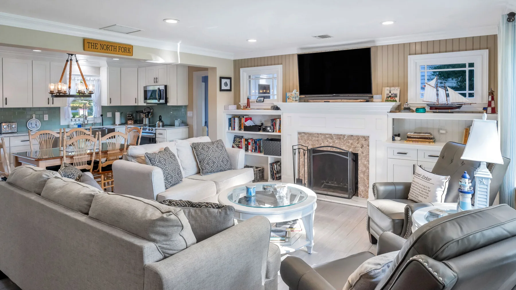 A living room with seating, a fireplace, and an adjoining dining area.