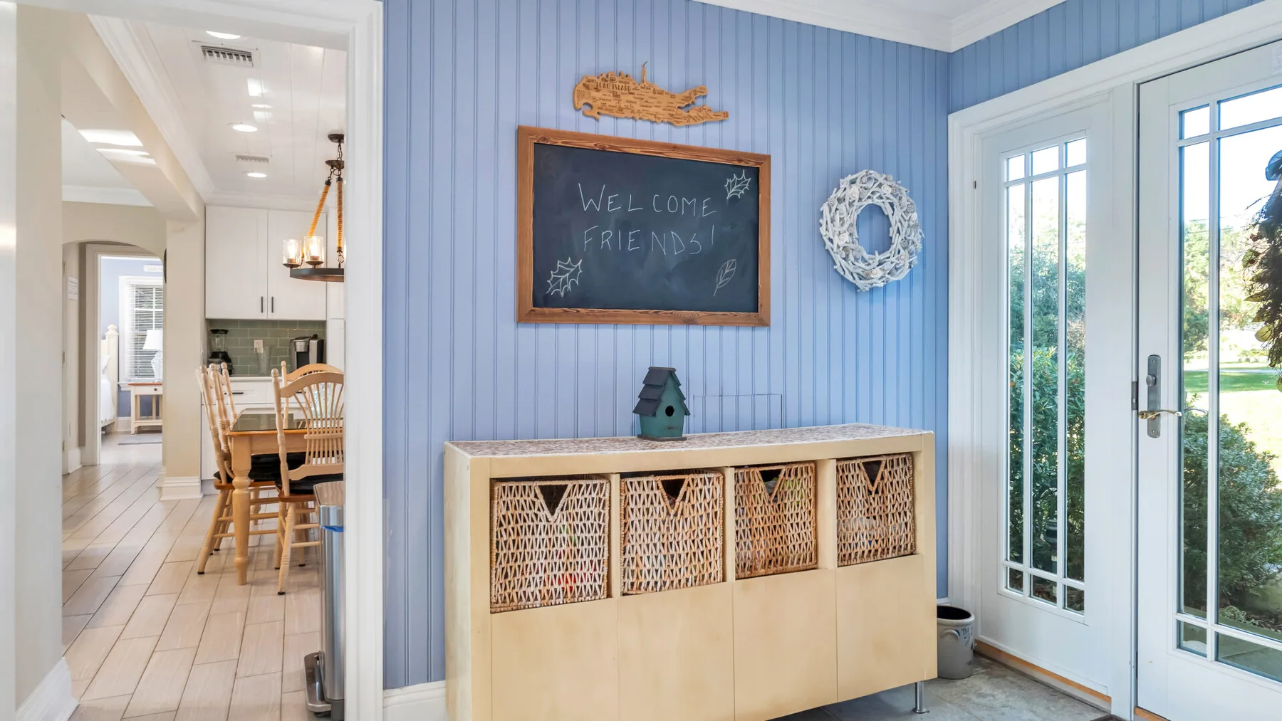 A blue-paneled entryway with a storage cabinet and glass doors.