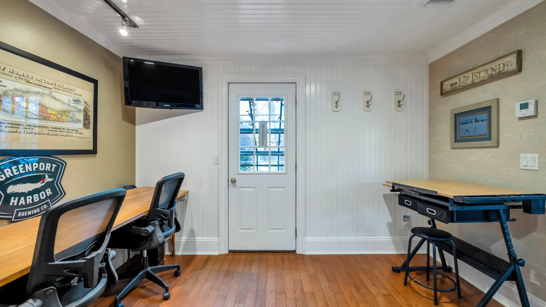 A compact office room with desks, seating, and a door with a window.
