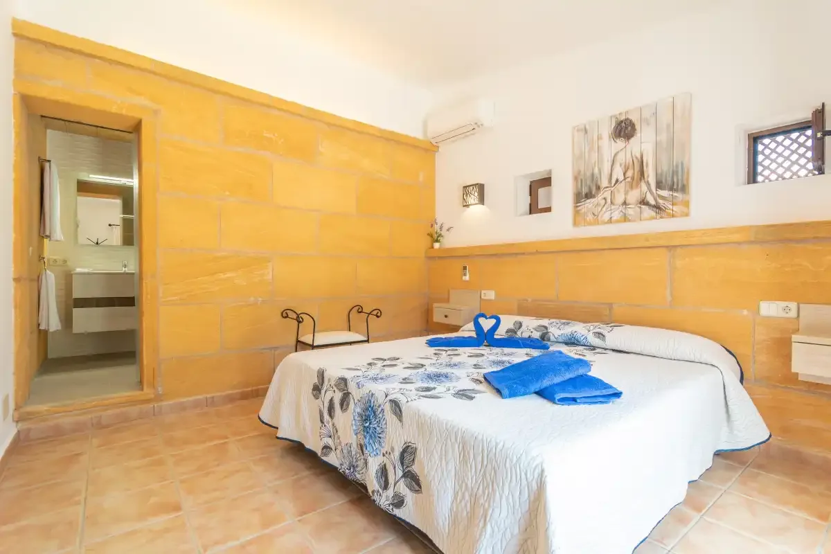 Un dormitorio con una cama doble vestida con ropa de cama blanca y azul.