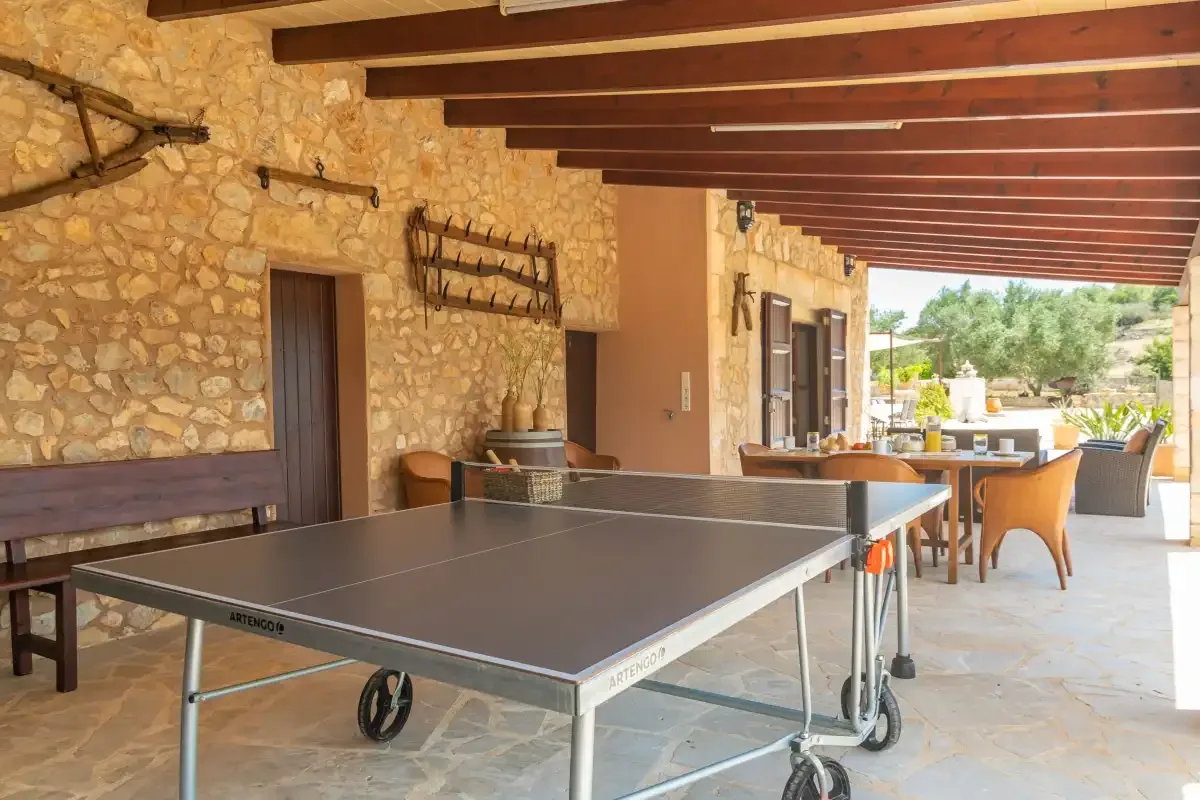 Un patio cubierto con una mesa de ping-pong y asientos al aire libre.