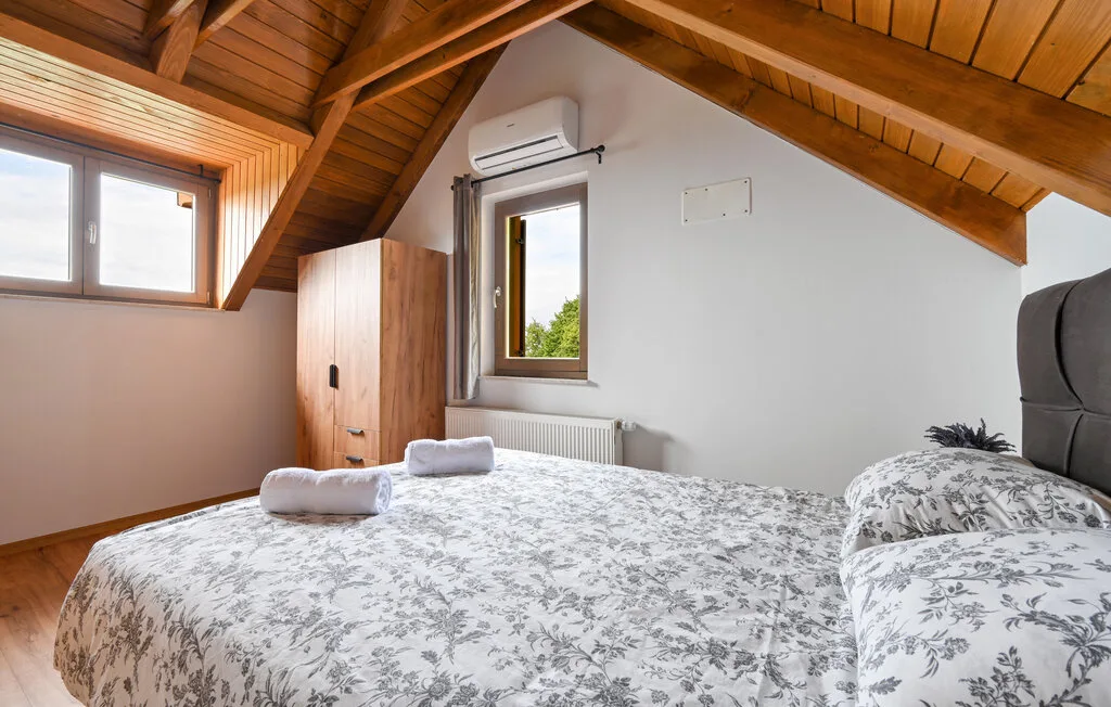 Un dormitorio con una cama grande bajo un techo inclinado de madera.