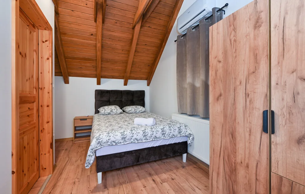 Un dormitorio con una cama bajo un techo inclinado de madera.
