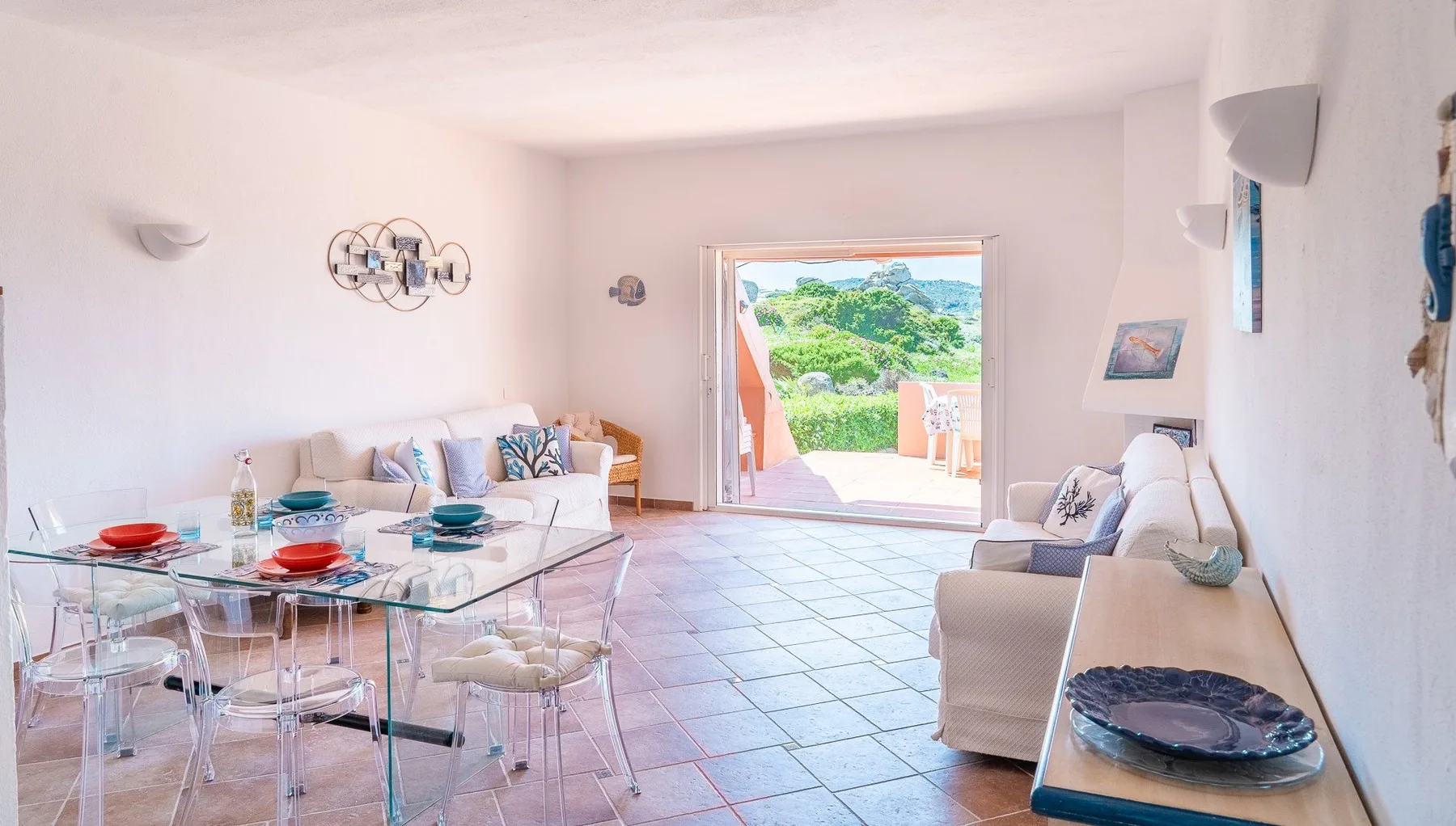 A bright living and dining room opens onto a terrace with green views.