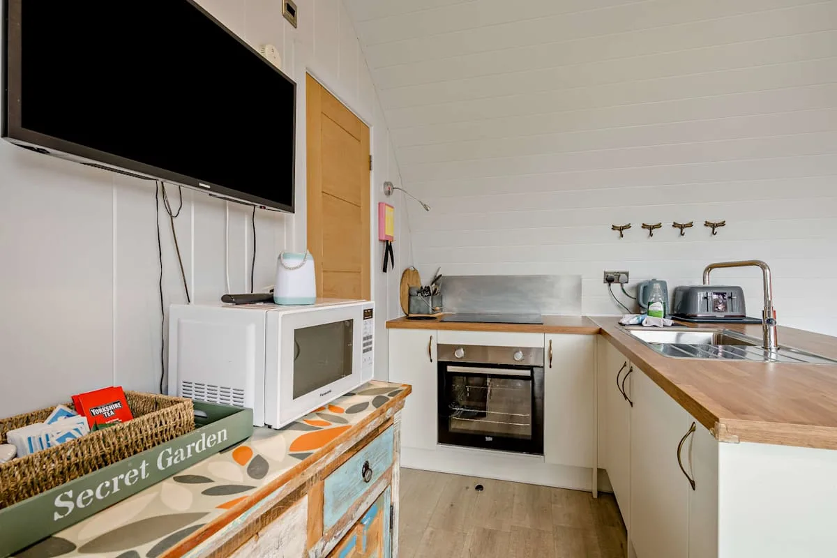 A compact kitchen with a countertop, sink, and built-in oven.
