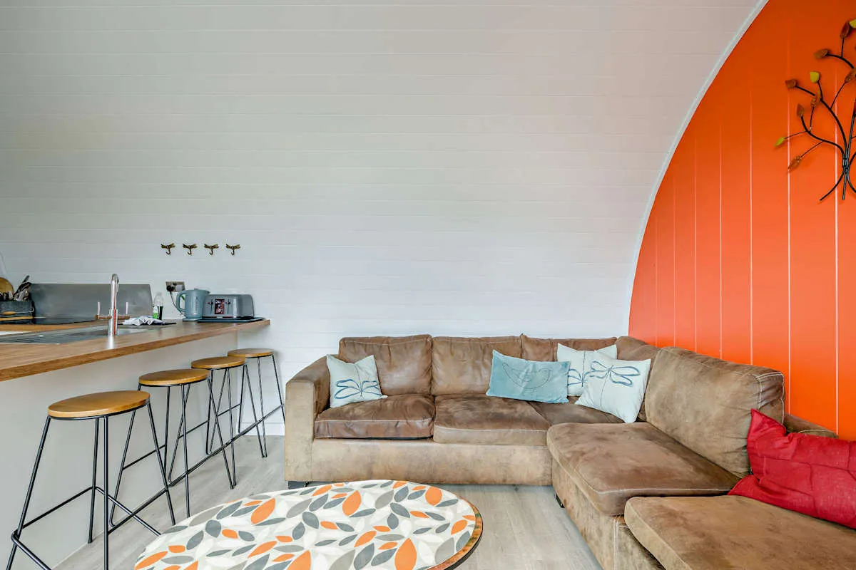 A living room with a sectional sofa and a small round table.