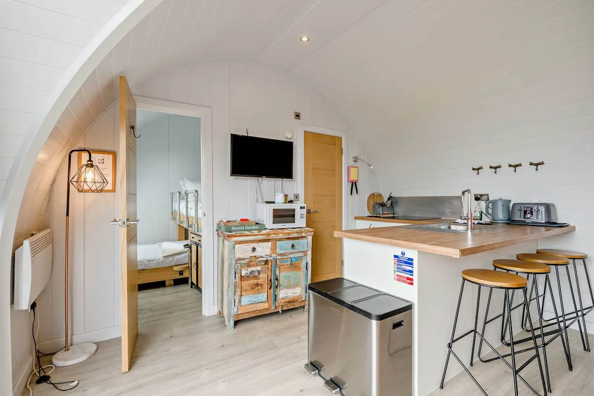 A bright kitchen with a breakfast bar and stools.