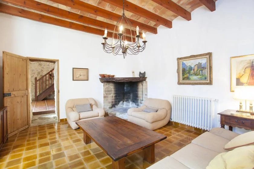 A living room with seating around a wooden coffee table and fireplace.