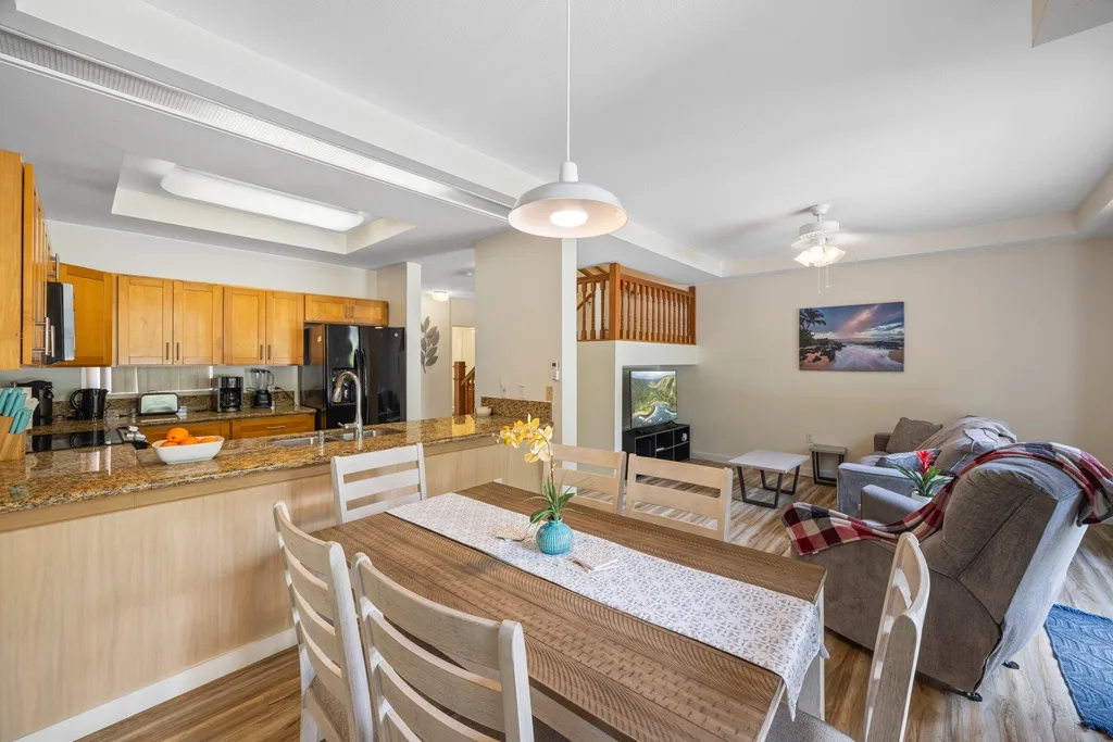 Espacio abierto de comedor y sala de estar con cocina y mesa de comedor.