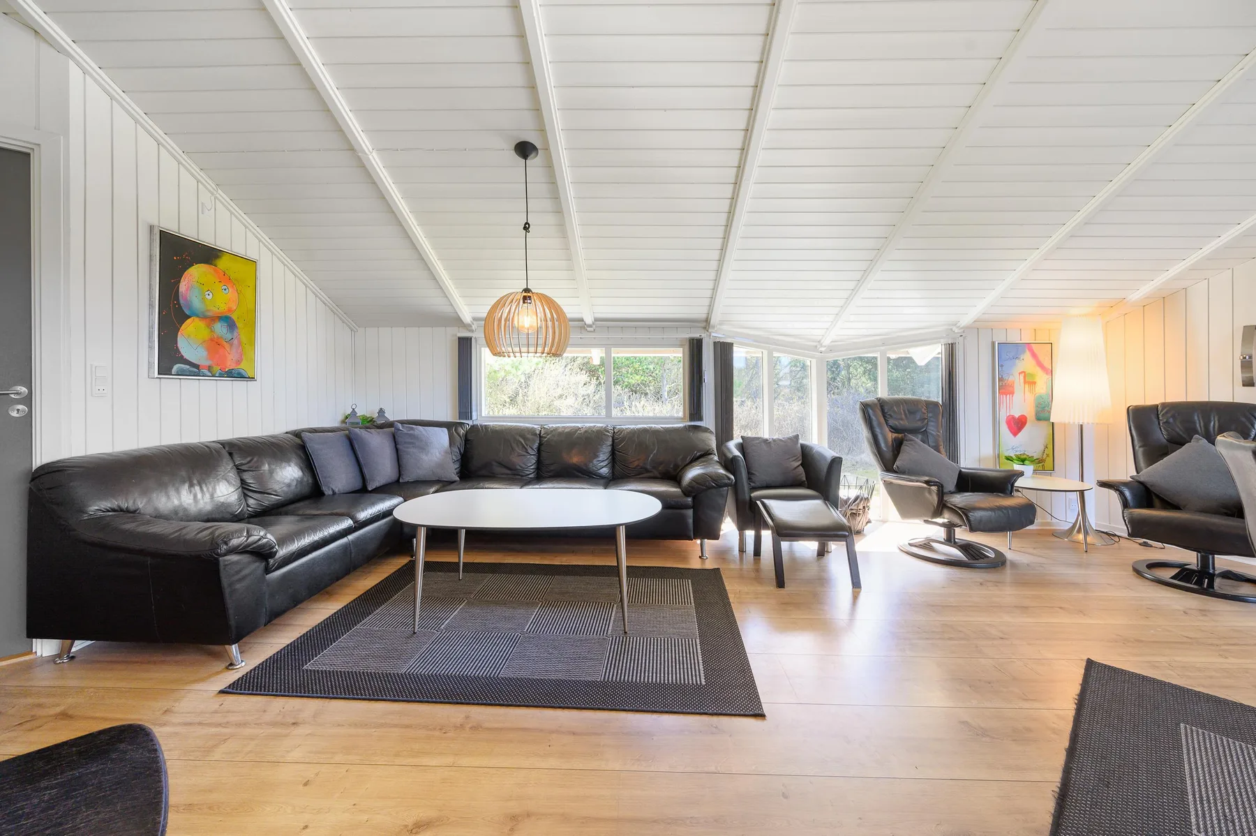 A bright living room has seating arranged around a low coffee table.