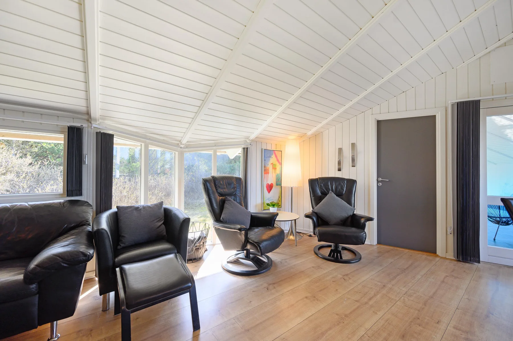 A bright lounge with reclining seating beside large windows.