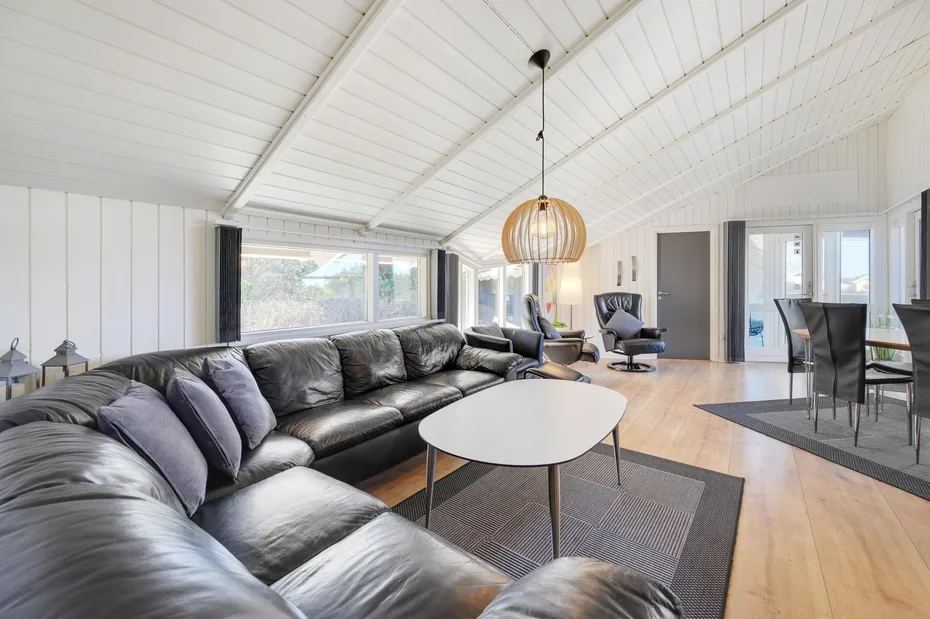 A bright living room with a sectional sofa and a dining area.