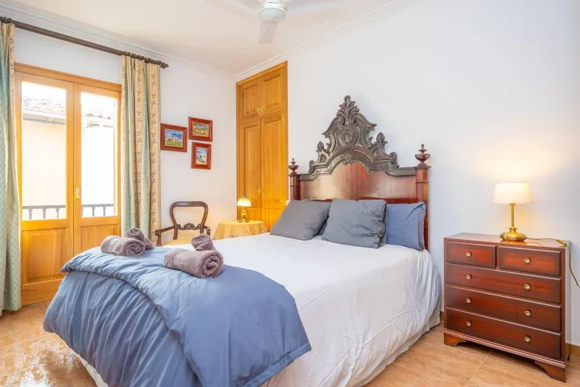 Un dormitorio con una cama grande, cabecero de madera y cómoda junto a la cama.